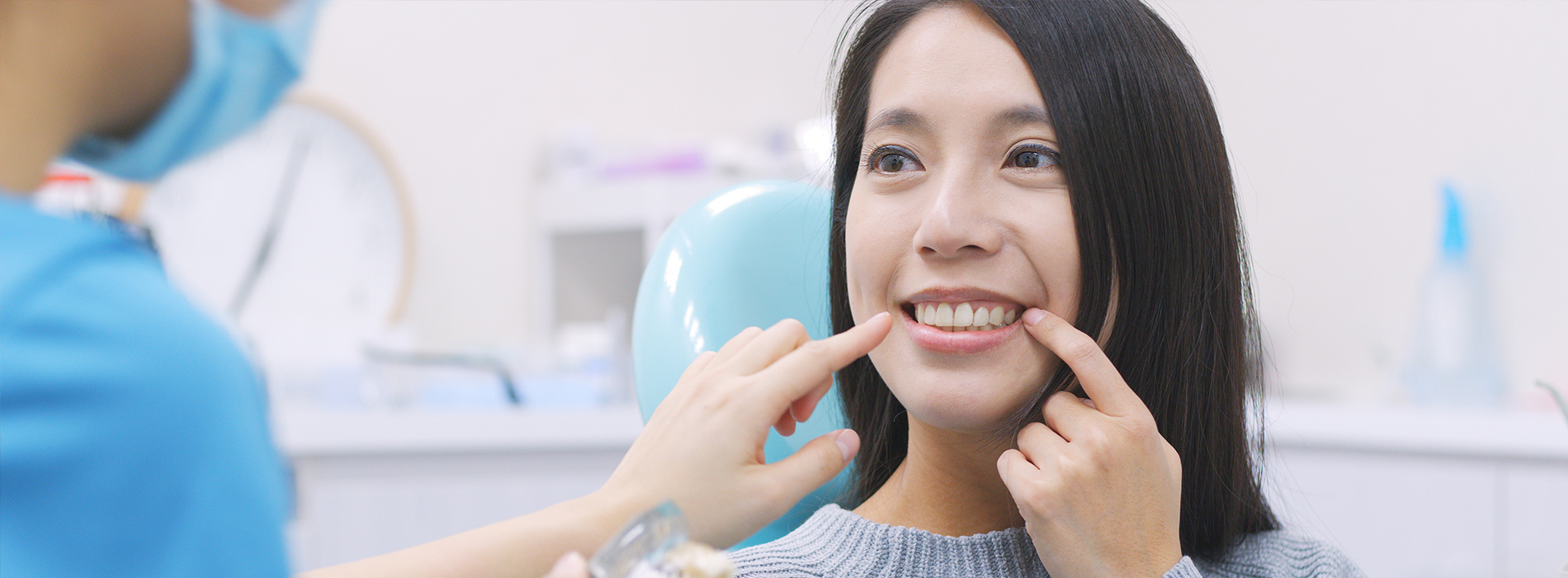 A dentist performing a dental procedure with a patient seated in the chair.