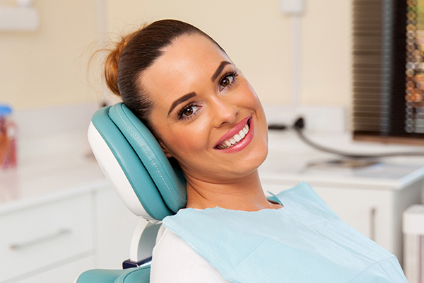 Woman in dental chair, smiling and looking at the camera.