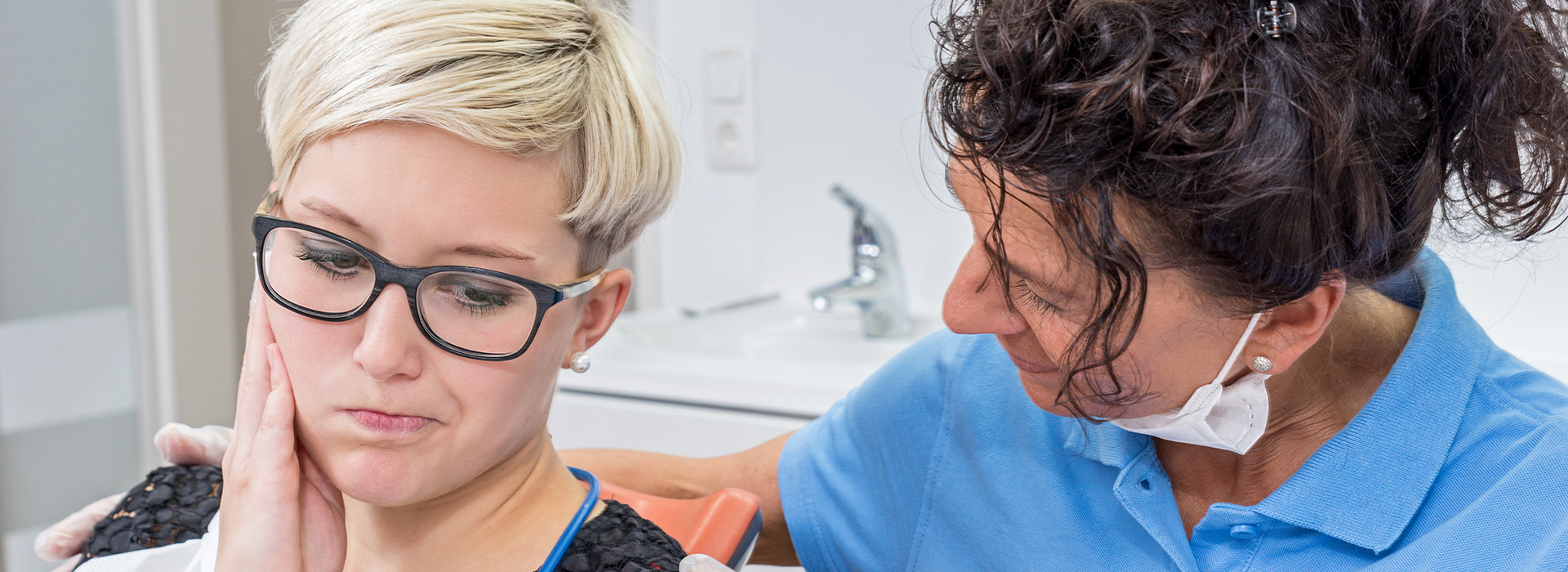 A photograph of a dental hygiene session, featuring a patient and a dentist in a professional setting.