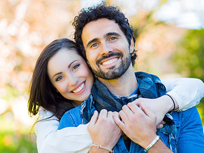 A man and a woman, both smiling, posing together for a photograph.