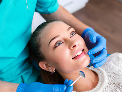 A dental professional performing a procedure on a patient's teeth.